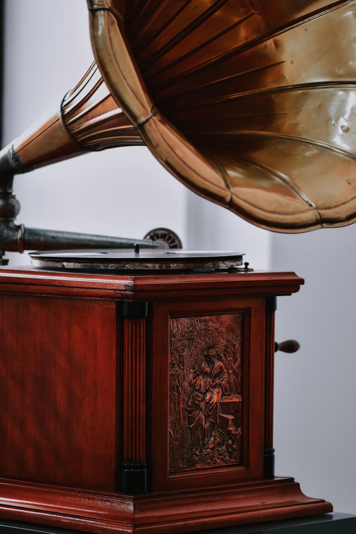 Close-up of a vintage brass gramophone with ornate wooden base, perfect for antique decor.