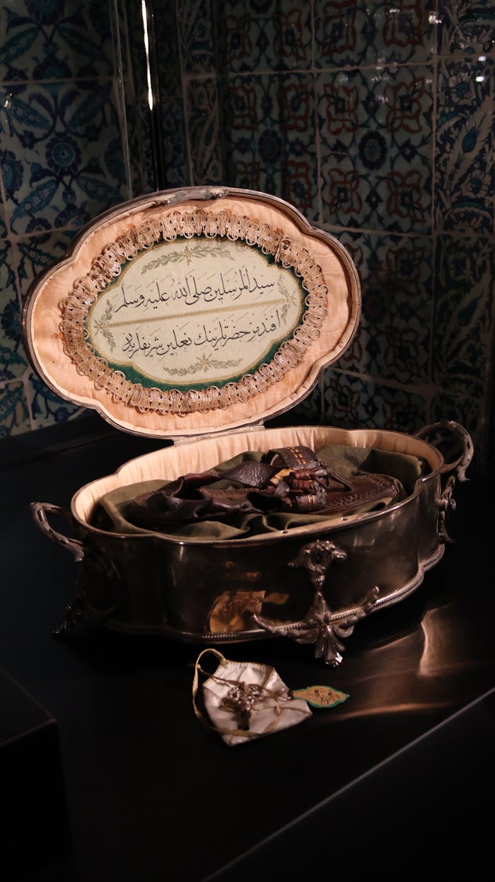 Antique silver box with Arabic calligraphy on ornate ceramic plate, rich in cultural heritage.